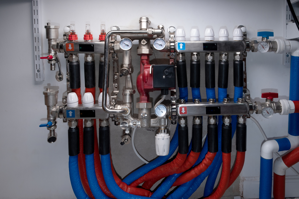 Rozdzielacz ogrzewania podłogowego z pompą obiegową, manometrami i przewodami zasilania/powrotu