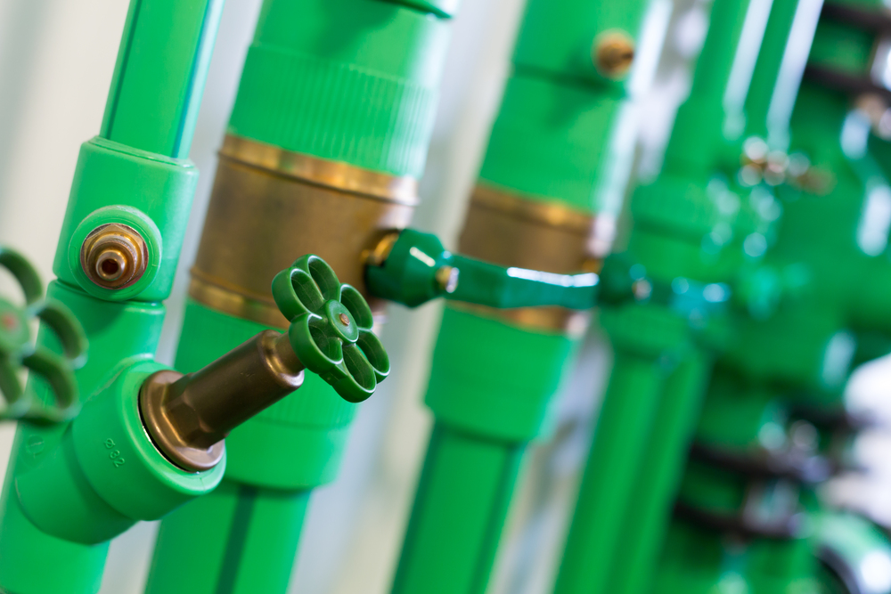 Zawory i armatura mosiężna na instalacji wodnej z zielonych rur PP
